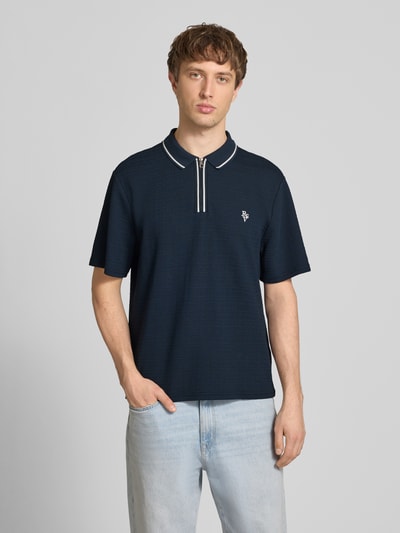 Männermodel trägt Regular Fit Poloshirt mit Reißverschluss und Label-Stitching von REVIEW, dunkelblau mit Strukturmuster, Ganzkörperansicht von vorne.