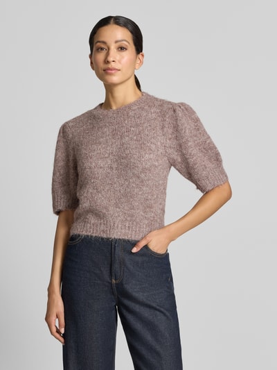 Modelka nosi sweter o kroju regular fit z dodatkiem wełny model 'NOVAH' od VERO MODA, kolor brązowy, faktura puszysta, damski sweter, ujęcie całej sylwetki z przodu.
