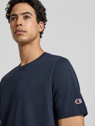 Mannenmodel draagt T-shirt met Rundhalsausschnitt im 2er-Pack van CHAMPION in donkerblauw, puur katoen, regular fit, labeldetail, set van 2, ruglengte maat M 69 cm, nahaufnahme bovenlichaam.