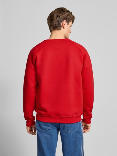 Männermodel trägt Sweatshirt mit Logo und Rundhalsausschnitt von adidas Originals in Rot, Baumwoll-Elasthan-Mix, Ganzkörperansicht Rückansicht.