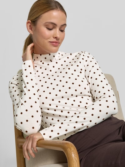 Frauenmodel trägt Cropped Longsleeve mit Polka Dots von Style Icon Collection in Weiß und Braun, Stehkragen, Regular-Fit, Körpernahe Passform, langärmelig, Rückenlänge bei Größe S: 42 cm, Nahaufnahme Oberkörper.