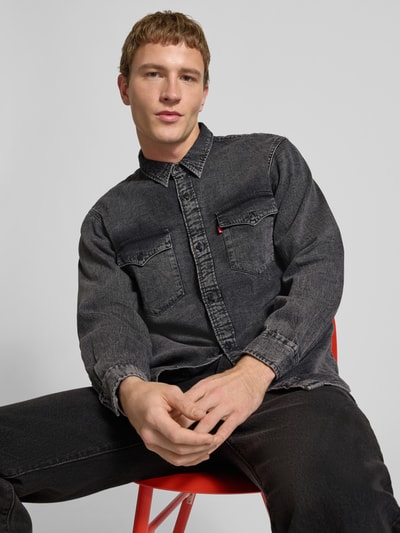 Männermodel trägt Relaxed Fit Jeanshemd mit Brusttaschen Modell 'WESTERN' von Levi's® aus reiner Baumwolle in Schwarz, Nahaufnahme Oberkörper.
