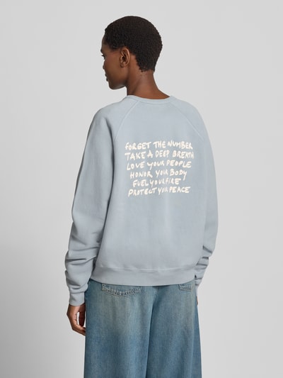 Vrouwenmodel draagt Relaxed Fit Sweatshirt uit puur katoen met statementprint van ba&sh, lichtblauw, ribboorden, lange mouw, Raglanmouwen, statementprint op de rug, bies, geheel te zien vanachter