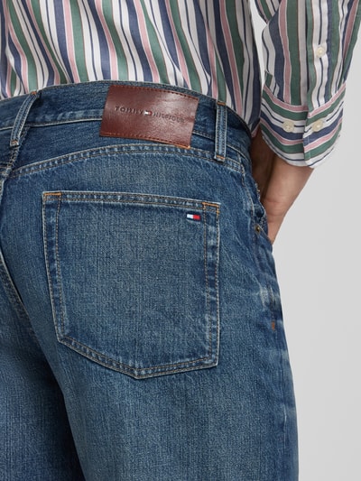 Mężczyzna nosi Straight Fit Jeans aus reiner Baumwolle Modell 'DOVER' von Tommy Hilfiger, denim, 5 kieszeni, łatka z logo, detailaufnahme tyłu.
