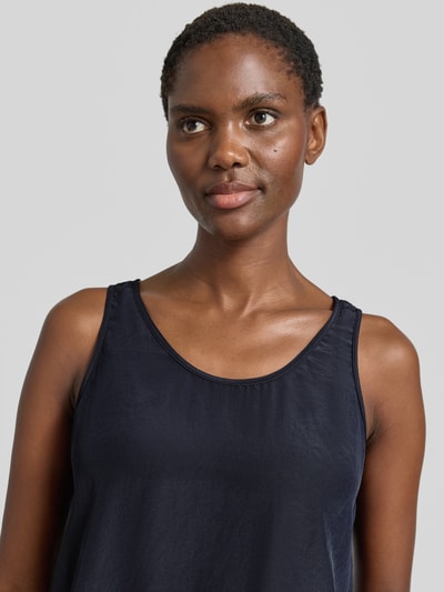 Frauenmodel trägt Blusenshirt mit Rundhalsausschnitt und Label-Detail von Marc Cain aus Satin in Straight Fit, Rückenlänge 52 cm, Nahaufnahme Oberkörper.