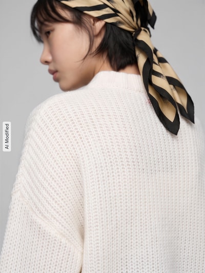 Frauenmodel trägt Oversized Pullover aus Woll-Mix aus Alpaka-Anteil Modell 'Sloossy' von HUGO, cremefarben, Damen Pullover, Ganzkörperansicht Rückansicht, KI-modifiziertes Bild.