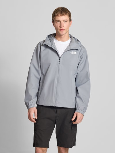 Männermodel trägt Jacke mit Kapuze von The North Face in Grau mit Label-Print, Reißverschlusstaschen, Regular Fit, Ganzkörperansicht von vorne.