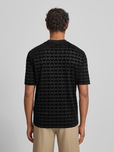 Männermodel trägt T-Shirt mit Label-Stitching von Emporio Armani, schwarz gemustert, Lyocell-Baumwoll-Mix, Regular-Fit, Ganzkörperansicht Rückansicht.