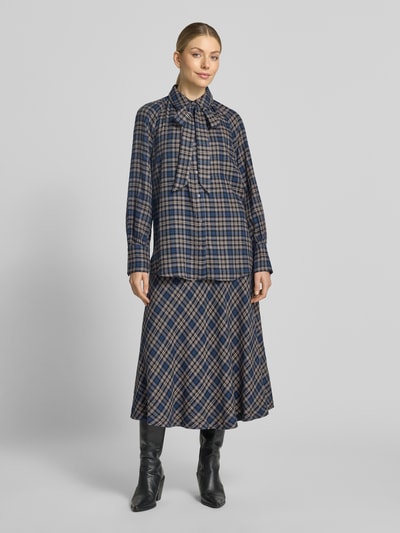 Frauenmodel trägt Regular Fit Hemdbluse aus Viskose-Mix von Oui mit Zierschleife, kariertem Muster, langen Ärmeln, Ganzkörperansicht von vorne.