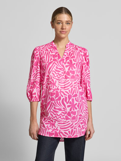 Vrouwenmodel draagt Relaxed Fit Tunika-Bluse mit floralem Allover-Print van Christian Berg Woman in roze-witte tinten, pure katoen, tuniekhals, 3/4-mouw, elastische mouwuiteinden, ruglengte 84 cm bij maat 36, mouwlengte 46 cm bij maat 36, geheel van voren.