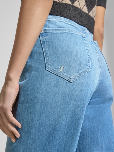 Frauenmodel trägt Jeans in 7/8-Länge im Used-Look Modell 'HANNI' von Raffaello Rossi, Baumwoll-Mix mit Stretch-Anteil, Relaxed-Fit, Eingrifftaschen, Nahaufnahme Rückansicht.