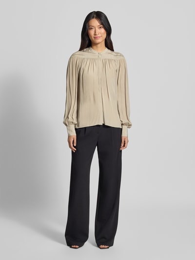 Frauenmodel trägt Regular Fit Langarmbluse aus reiner Viskose Modell 'C_Bethena' von BOSS Orange in Beige mit schwarzen Stoffhosen, Ganzkörperansicht von vorne.