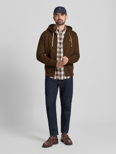 Männermodel trägt Sweatjacke mit Kapuze von Polo Ralph Lauren aus Baumwoll-Mix mit Lockerer-Schnitt, Tunnelzug, Reißverschluss, Label-Stitching, Eingrifftaschen, gerippte Abschlüsse, Ganzkörperansicht von vorne.
