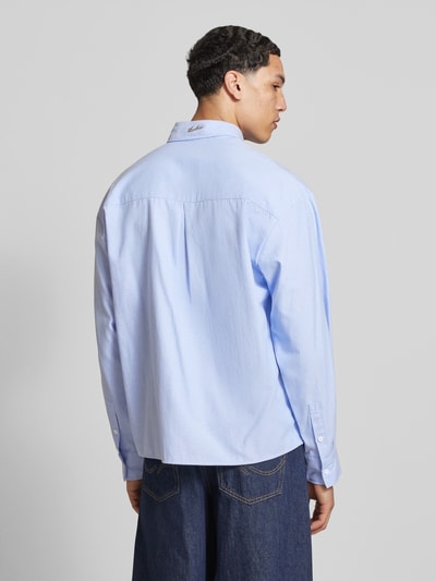 Męski model nosi Regular Fit Freizeithemd mit Motiv-Stitching od ANOTHER COTTON LAB, jasnoniebieski, bawełniany miks, model 'Everyday Pocket', guziki, kieszeń na piersi, haft motywu, sportowe mankiety, długość tyłu w rozmiarze M: 71 cm, szerokość w rozmiarze M: 53 cm, długość rękawa w rozmiarze M: 62 cm, widok całej sylwetki z tyłu.