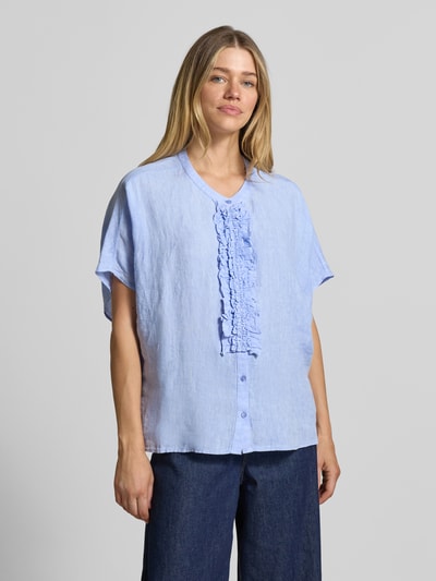 Frauenmodel trägt Relaxed Fit Leinenbluse mit Rüschen von Milano Italy in Hellblau, reine Leinenstruktur, Knopfleiste, Ganzkörperansicht von vorne.