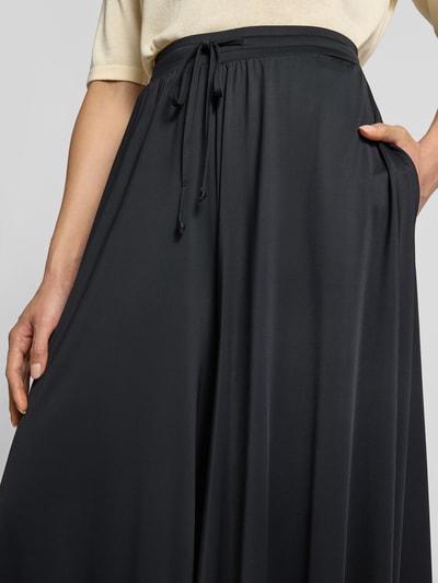 Kobiece modelka nosi Wide Leg Hose mit Tunnelzug od Oui, czarne spodnie z szerokimi nogawkami, Mieszanka materiałów z dodatkiem streczu, elastyczny pas, tunel, Szerokość w rozmiarze 36: 37 cm, Długość wewnętrzna nogawki w rozmiarze 36: 61 cm, zbliżenie na górną część ciała.