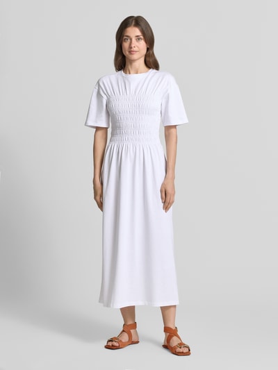 Frauenmodel trägt Midikleid mit Smok-Details von Jake*s Casual in Weiß, reine Baumwolle, taillierter Schnitt, Ganzkörperansicht von vorne.