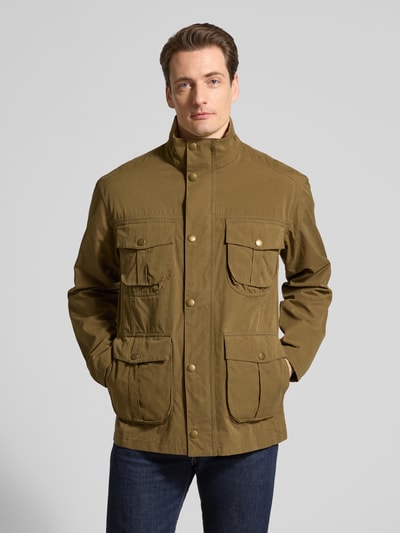 Männermodel trägt Regular Fit Jacke aus Baumwoll-Mix Modell 'SANDERLING' von Barbour in Unifarbe Oliv, Ganzkörperansicht von vorne.