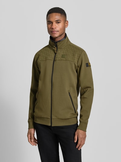 Męski model nosi Sweatjacke mit Reißverschluss od PME Legend, bawełna z elastanem, krój prosty, stójka, zamek, detale z logo, kieszenie na zamek, ściągacze, długość tyłu 72 cm, długość rękawa 67 cm, widok całej sylwetki z przodu