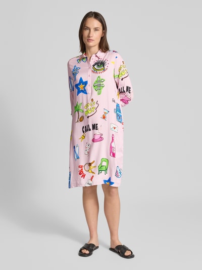 Frauenmodel trägt Relaxed Fit Hemdblusenkleid aus reiner Viskose von Milano Italy, rosa mit bunten Printmotiven, knielang, Ganzkörperansicht von vorne.