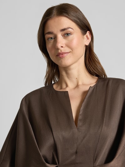Frauenmodel trägt knielanges Kleid mit Viskose-Anteil Modell 'VIANNA' von Copenhagen Muse, brauner Satin, strukturierte Optik, Nahaufnahme Oberkörper.
