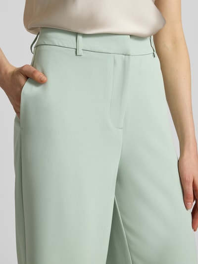 Vrouwenmodel draagt Stoffen broek met steekzakken model 'Jana' van GUIDO MARIA KRETSCHMER WOMAN in mintgroen, materiaalmix met stretch, uitlopend model, haakjes- en ritssluiting, strookzakken achter, bandwijdte maat 36: 38 cm, binnenbeenlengte maat 36: 84 cm. Detailopname heup.