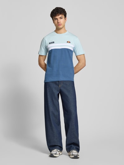 Männermodel trägt Herren T-Shirt mit Label-Stitchings Modell 'VENIRE' von Ellesse in Blau und Weiß aus reiner Baumwolle, Regular-Fit, Ganzkörperansicht von vorne. Rückenlänge bei Größe M: 66 cm, Rundhalsausschnitt.