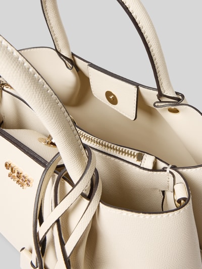 Produktfoto, cremefarbene Handtasche in Leder-Optik Modell 'Amorette' von GUESS mit Magnetverschluss, Logo-Detail und abnehmbarem Trageriemen, strukturierte Oberfläche.