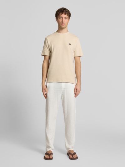 Männermodel trägt T-Shirt mit Label-Detail Modell 'FILLIP' von Blend in Beige, Reine Baumwolle, Gerader-Schnitt, Ganzkörperansicht von vorne.