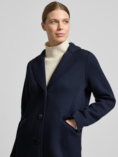 Modelka nosi Płaszcz mit Kapuze und Pattentaschen von Christian Berg Woman Selection, granatowy, mieszanka materiałów z dodatkiem wiskozy, krój regular fit, kaptur z tunelem, listwa guzikowa, kieszenie z patką, długość tyłu w rozmiarze 36: 88 cm, szerokość ramion w rozmiarze 36: 45 cm, szerokość w rozmiarze 36: 50 cm, długość rękawów w rozmiarze 36: 57 cm, gładka tekstura, widoczne detale szwów, na zdjęciu: zbliżenie na górną część ciała