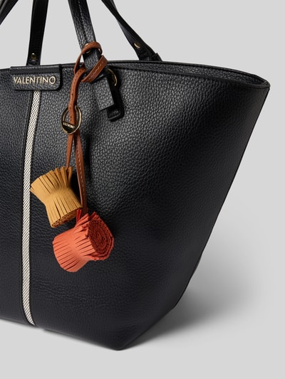 Produktfoto, Handtasche mit Label-Applikation Modell 'HYBRIS' von VALENTINO BAGS, schwarze, grob genarbte Textur, Kontrastnaht, brauner und roter Anhänger, Damen Handtasche mit Reißverschluss, Tragehenkel, Detailaufnahme.