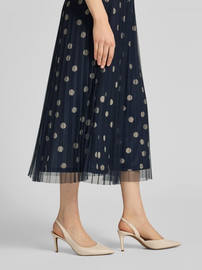Frauenmodel trägt Leicht ausgestellter Midi-Rock mit Polka Dots von s.Oliver BLACK LABEL, marineblau, Plissee, Jersey-Unterrock, Ganzkörperansicht von vorne.