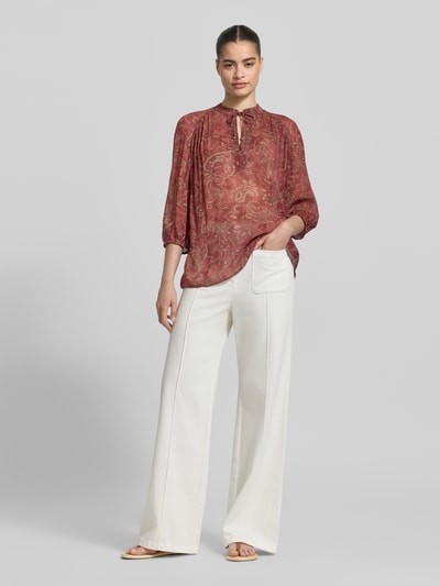 Frauenmodel trägt Regular Fit Bluse aus Viskose mit Schnürung und 3/4-Arm von Jake*s Collection im Allover-Look, Stehkragen, Rückenlänge 65 cm, Ärmellänge 55 cm, Ganzkörperansicht von vorne.