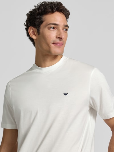 Männermodel trägt T-Shirt aus Lyocell-Mix mit Label-Stitching von Emporio Armani, schlanke Passform, Rundhalsausschnitt, Nahaufnahme Oberkörper.