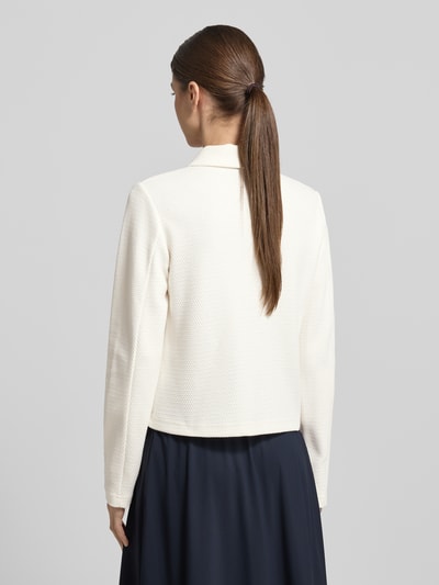 Frauenmodel trägt Regular Fit Blazer mit Strukturmuster und Pattentaschen von Betty Barclay in Creme, Rückansicht, Ganzkörperansicht Rückansicht. Rückenlänge bei Größe 36: 55 cm, Brustweite: 49 cm, Ärmellänge: 65 cm, mit Umlegekragen und Knopfleiste.