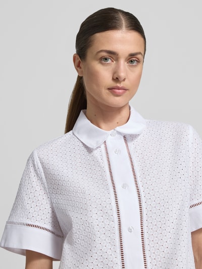 Frauenmodel trägt Regular Fit Bluse mit Lochstickerei Modell 'Blanc' von JOOP! aus weißer Baumwolle, Nahaufnahme Oberkörper.