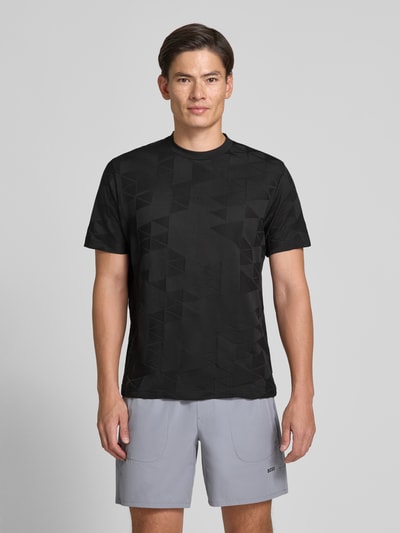 Männermodel trägt schwarzes Regular Fit T-Shirt aus reiner Baumwolle Modell 'TS_NETWORK JQ' von BOSS Green, graue Shorts, Ganzkörperansicht von vorne.