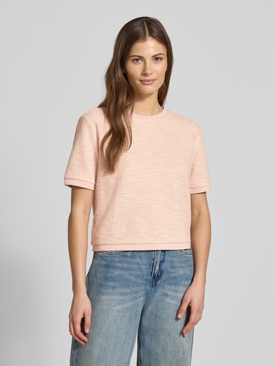 Frauenmodel trägt T-Shirt in Frotte-Optik mit Rundhalsausschnitt von Jake*s Collection im Boxy-Fit, Material-Mix mit Baumwoll-Anteil, pastellrosa mit strukturierter Oberfläche, kombiniert mit blauen Jeans, Ganzkörperansicht von vorne.