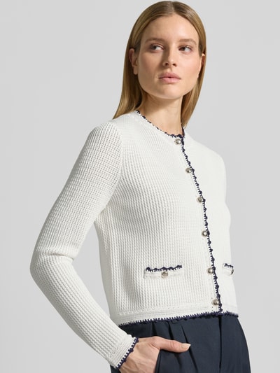 Vrouwenmodel draagt Strickjacke aus Viskose-Mix Modell 'Kumma' van JOOP!, regular fit, witte kleur, contrasterende stiksels, ronde hals, knoopsluiting, textuur met fijne structuur, detailzakken, vooraanzicht bovenlichaam