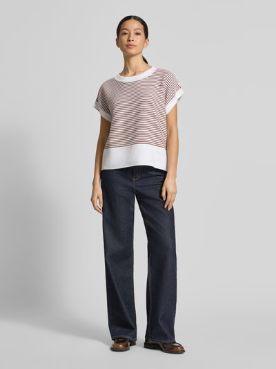 Frauenmodel trägt Damen T-Shirt aus reiner Baumwolle in Strick-Optik Modell 'Kipe' von JOOP!, lockere Passform, Rundhalsausschnitt, Label-Detail, Querstreifen in Weiß und Rot, Rückenlänge 56 cm, Ärmellänge 14 cm, Ganzkörperansicht von vorne.