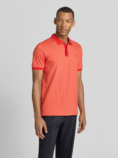Männermodel trägt Regular Fit Poloshirt mit Logo-Stitching von Lerros in Koralle, Polokragen, kurze Knopfleiste, Ganzkörperansicht von vorne.