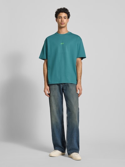 Männermodel trägt Oversized T-Shirt aus reiner Baumwolle Modell 'NALONO' von Hugo Blue, unifarben, Rundhals, kurzarm, Ganzkörperansicht von vorne.