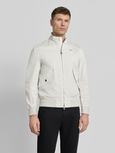 Männermodel trägt Jacke mit Zweiwege-Reißverschluss Modell 'Badger' von Blauer Usa im Baumwoll-Elasthan-Mix Regular-Fit, Stehkragen und Pattentaschen, Farbe hell, glatte Textur, Ganzkörperansicht von vorne.
