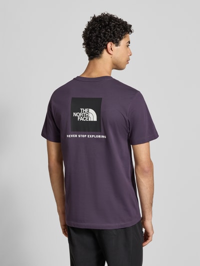 Männermodel trägt Regular Fit T-Shirt aus Baumwoll-Mix Modell 'EVOLUTION' von The North Face in Dunkellila mit Label-Detail, Ganzkörperansicht Rückansicht. Herren T-Shirt, Rundhalsausschnitt, Rückenlänge bei Größe M 70 cm.