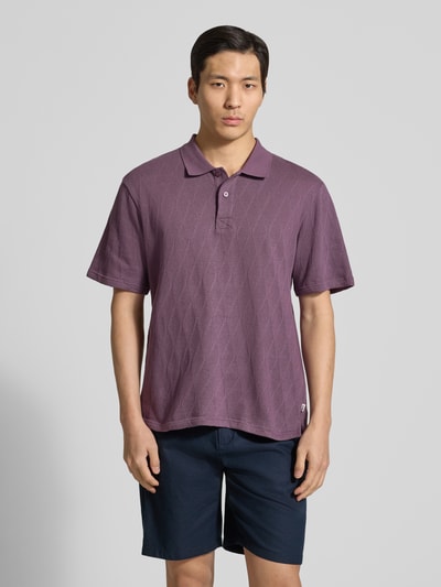 Männermodel trägt Regular Fit Poloshirt mit Knopfleiste Modell 'Gabriel' von Wood Wood aus Reine Baumwolle, dunkelviolett, Ganzkörperansicht von vorne. Rückenlänge bei Größe M: 70 cm.
