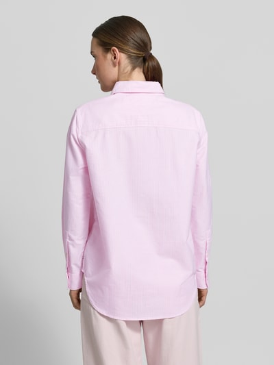 Frauenmodel trägt Relaxed Fit Hemdbluse aus reiner Baumwolle von Tommy Hilfiger, efekt: jednolity kolor, krój relaxed fit, kołnierzyk koszulowy, detal z logo, pas na plecach, listwa guzikowa, długi rękaw, mankiet, zaokrąglone wykończenie, wykończenie materiału: oxford, bawełna; Ganzkörperansicht Rückansicht