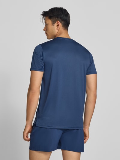 Männermodel trägt dunkelblaues Funktionsshirt mit Rundhalsausschnitt und Logo von New Balance, glatte Struktur, Ganzkörperansicht Rückansicht, Herren Funktionsshirt von New Balance, Regular Fit, Rückenlänge Größe M 69 cm.