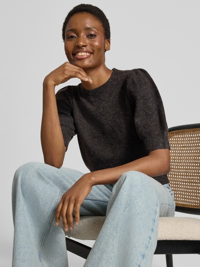 Frauenmodel trägt Regular Fit Pullover mit Puffärmeln von VERO MODA in Dunkelgrau zu hellblauer Jeans, Nahaufnahme Oberkörper.
