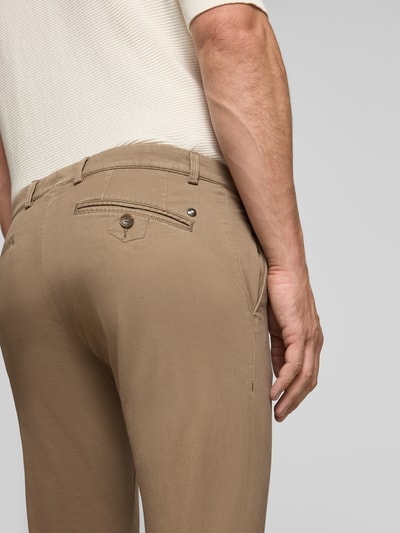 Männermodel trägt Slim Fit Chino aus Baumwoll-Mix von bugatti, Gesäßtaschen, Knopfverschluss, Detailaufnahme Rückansicht.