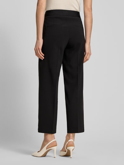 Frauenmodel trägt schwarze Straight Fit Stoffhose mit Ziernaht Modell 'Cameron' von Cambio, verkürzte Passform, Rückansicht, Ganzkörperansicht.
